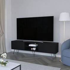 a living room with a couch, table and television on it's stand in front of a large flat screen tv