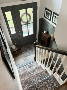 an overhead view of a stair case with two doors and a rug on the floor