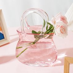 a pink vase filled with water and flowers