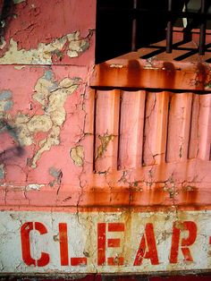 an old rusted sign on the side of a building that says clear street written in red