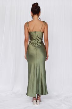 a woman in a green dress looking back