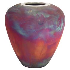 a colorful vase sitting on top of a white table