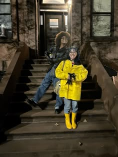 two people standing on the steps in front of a building