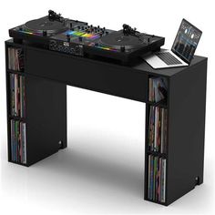 a dj desk with two turntables and cd's on it, sitting in front of a laptop