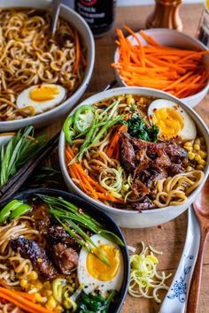 three bowls filled with noodles, meat and veggies on top of a wooden table