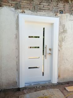 a white door sitting next to a brick wall