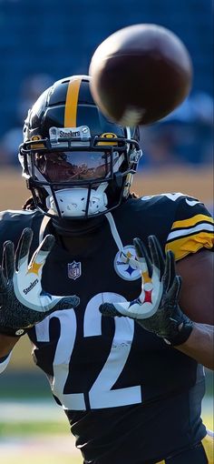 a football player throwing a ball in the air with his arm extended and wearing gloves