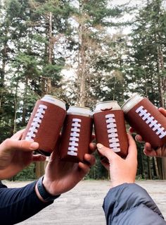 three people holding football cups in their hands