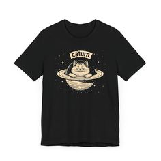 Caturn T-Shirt - Cosmic Cat Planet Graphic Tee 🌌🐱 Welcome to Caturn, the cutest planet in the galaxy! Our Caturn T-Shirt features an adorable cat lounging on Saturn’s rings, perfect for space enthusiasts and cat lovers alike. Made from high-quality fabric, this tee ensures both comfort and durability for your everyday adventures. Add a touch of cosmic cuteness to your wardrobe with this whimsical and unique graphic tee! 🌟✨ Why You'll Love It: 👕 Ultimate Comfort: Made with 100% Airlume combed Cat Lounging, Planet Graphic, Cosmic Cat, Cat Lounge, Cat Graphic Tee, Everyday Adventures, Cat Graphic, The Galaxy, Leisure Wear