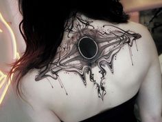 a woman with a black and white tattoo on her back