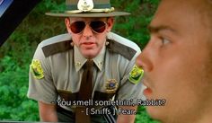 a man in uniform talking to another man who is wearing sunglasses and a hat with the words you smell something rabbit?