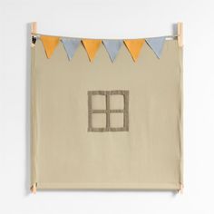 a wall hanging with a house made out of fabric and bunting on the side