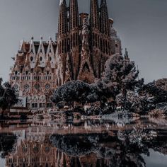 a very tall building with many spires on it's sides and trees in the foreground