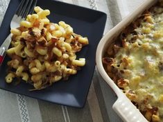 a casserole dish with macaroni and cheese on it next to a fork