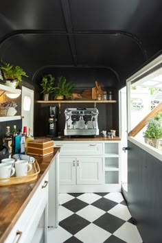 a black and white checkered floor in a kitchen with an espresso machine