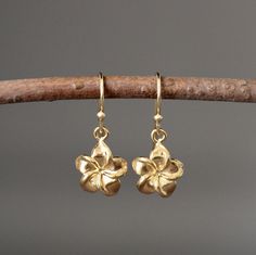 "Sweet and delicate 24k gold vermeil Plumeria flower charms dangle from 18k gold vermeil earwires. The perfect go-to-earrings for any occasion. Gold flower charms: 11x11mm Total length of earrings: 1\" All gold is gold vermeil. These earrings are also available in a larger size in silver... www.etsy.com/listing/693341987/silver-flower-earrings As the owner, maker, designer, and curator of this shop, I take great pride in providing you with jewelry that you will love to wear everyday, for special Cute Earrings Aesthetic Gold, Gold Plated Flower Charm Earrings, Gold Flower-shaped Earrings With Flower Charm, Gold Flower Earrings With Charm, Gold Dangle Earrings With Flower Charm, Handmade Yellow Gold Plated Flower Earrings, Gold Earrings With Flower Charm And Pendant, Gold Flower Pendant Earrings As Gift, Gold Dangle Flower Earrings In Sterling Silver