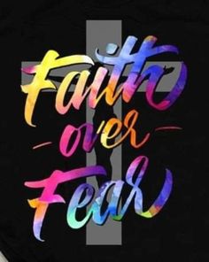 a cross with the words faith over fear painted on it in multicolored letters