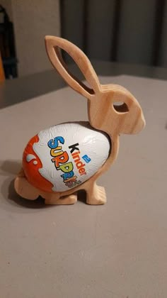 an orange and white plastic easter egg sitting in the shape of a rabbit on top of a table