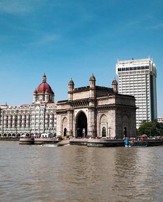 a large building sitting on top of a river next to tall buildings in the background