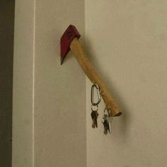 a hammer stuck in the wall with keys attached to it