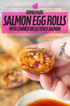 someone holding an egg roll with canned or leftover salmon sauce in their hand and the text homemade salmon egg rolls with canned or leftover salmon