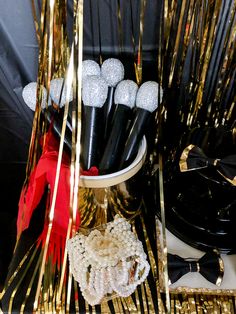 there are many black and white items on the table with gold streamers around them