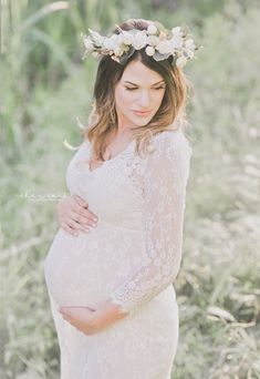 a pregnant woman wearing a flower crown in the grass