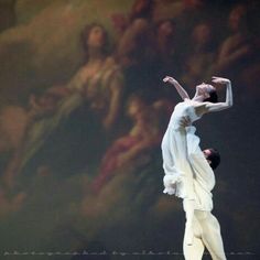 two dancers in white are performing on stage