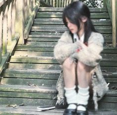 a woman sitting on steps with her legs crossed