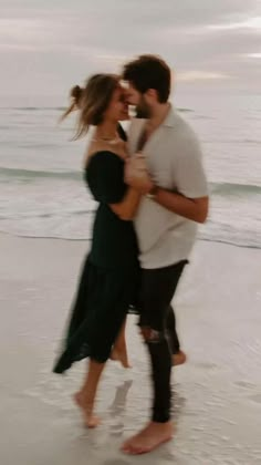 a man and woman hugging on the beach