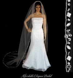 a wedding dress and veil on display in front of a black background