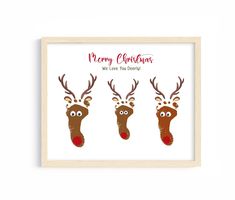 three reindeers with red noses and antlers on their heads are shown in a wooden frame