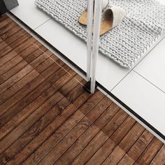 a bathroom with wooden floors and white walls