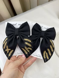 two black bows with gold leaves on them