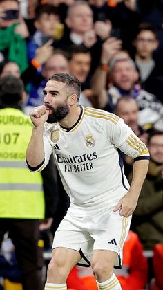 a man with a beard is standing on the soccer field and holding his hand up to his mouth