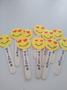 some wooden spoons with smiley faces on them and words written in different languages that read we love you