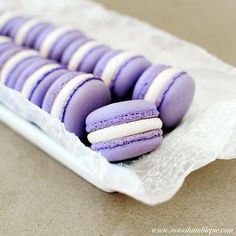 purple and white macaroons are on a plate