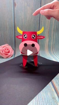 someone is making a paper cow that looks like it has horns