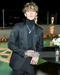 a man in a black suit standing next to a table