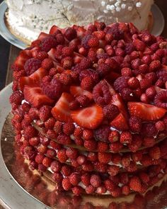 a triple layer cake with strawberries on top