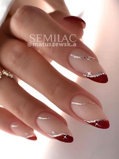 a woman's hand with red and white manies on it, holding onto her nails