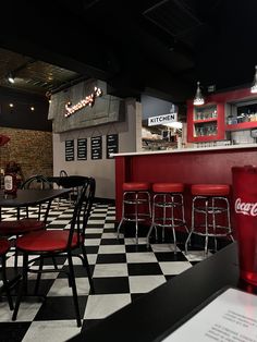 a checkered floor in a restaurant with red chairs and coca - cola cups on the counter