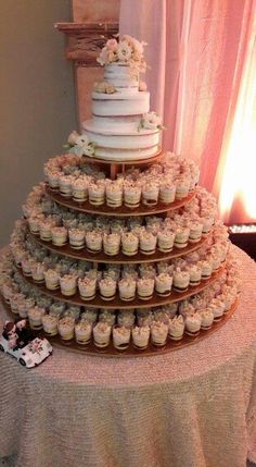 a wedding cake and cupcakes on a table