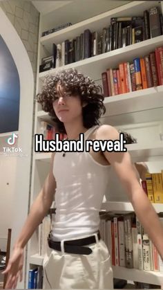 a man standing in front of a bookshelf with the words husband reveal on it