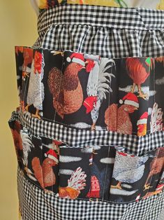 an apron with chickens and roosters on it is hanging from the back of a woman's waist