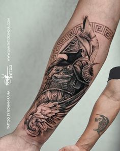 a man's arm with an eagle and helmet tattoo on it