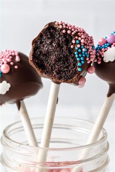 chocolate cake pops with pink and blue sprinkles in a mason jar filled with candy