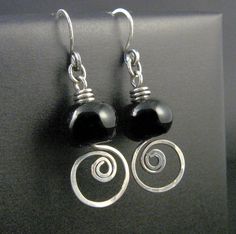 two black beads are hanging from silver earwires