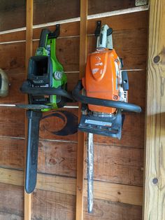 two chainsaws are hanging on the wall next to each other