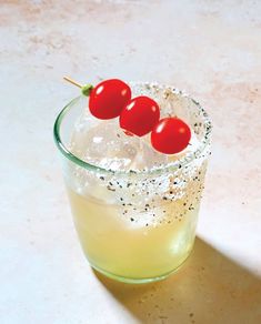 three cherries on the top of a drink in a glass with ice and sprinkles